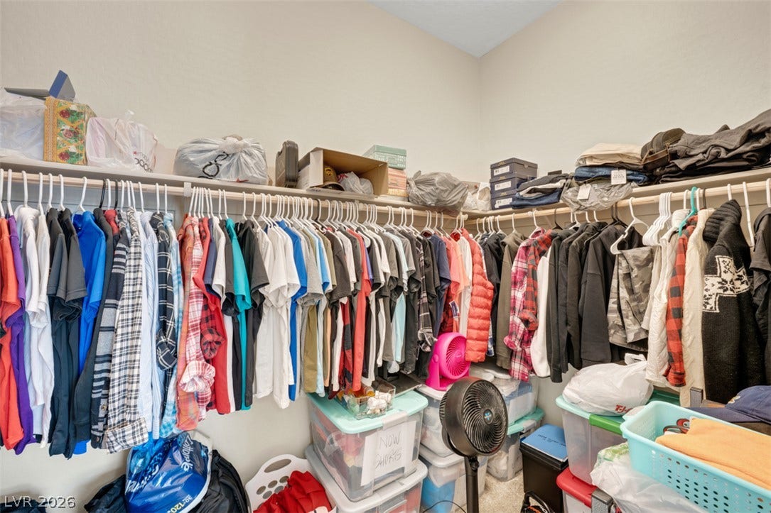 Generous hanging space and high shelves maximize organization in this functional walk-in closet.