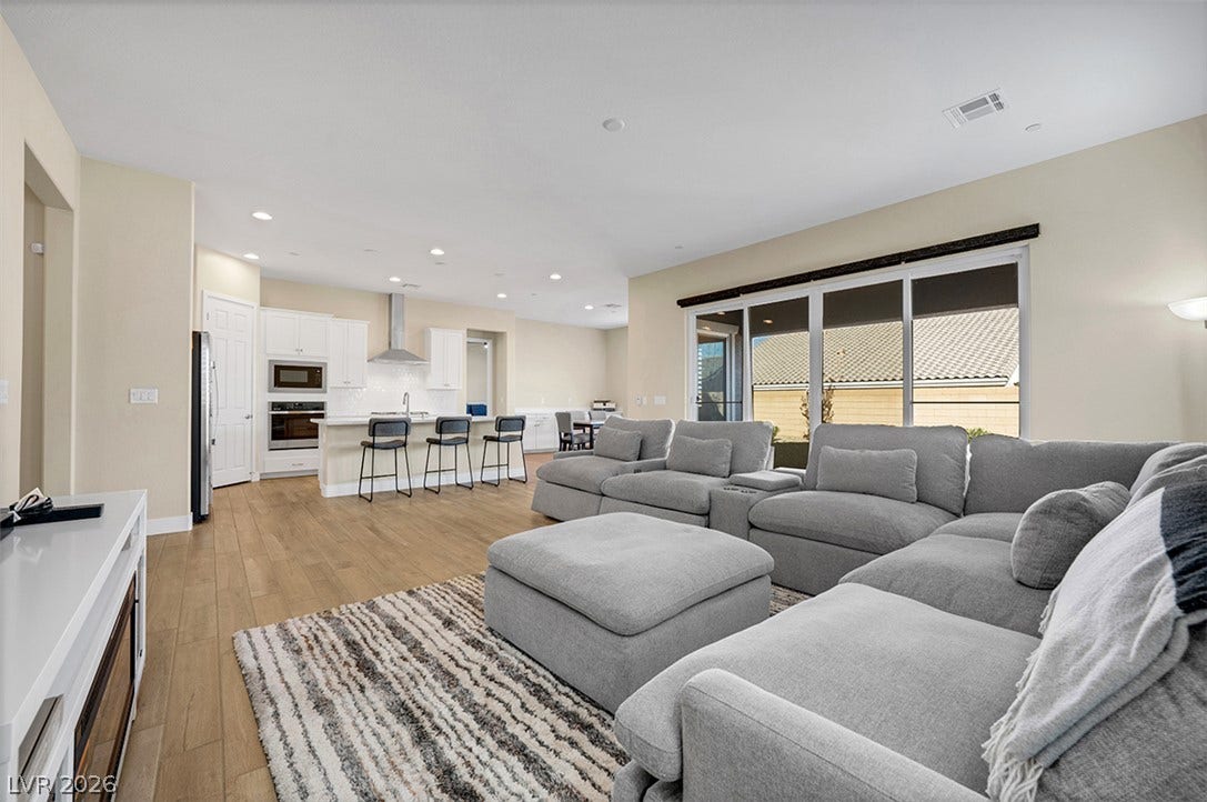 Warm wood flooring stretches across this airy, seamlessly integrated open-concept living space.