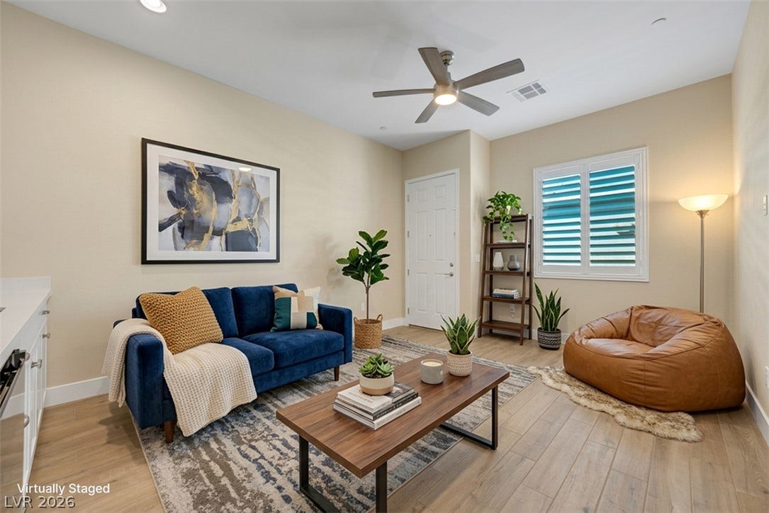 Warm wood flooring pairs beautifully with classic plantation shutters in this open-concept living area.