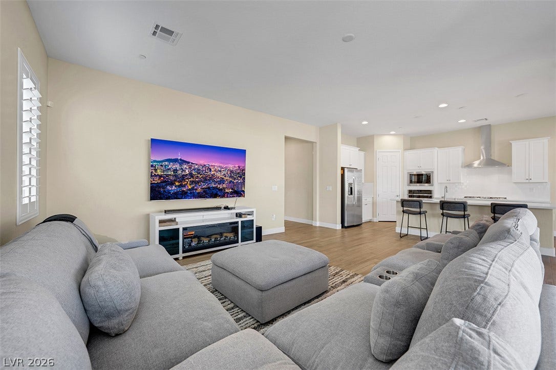 Smooth wood floors flow effortlessly through this expansive living area into the modern kitchen.