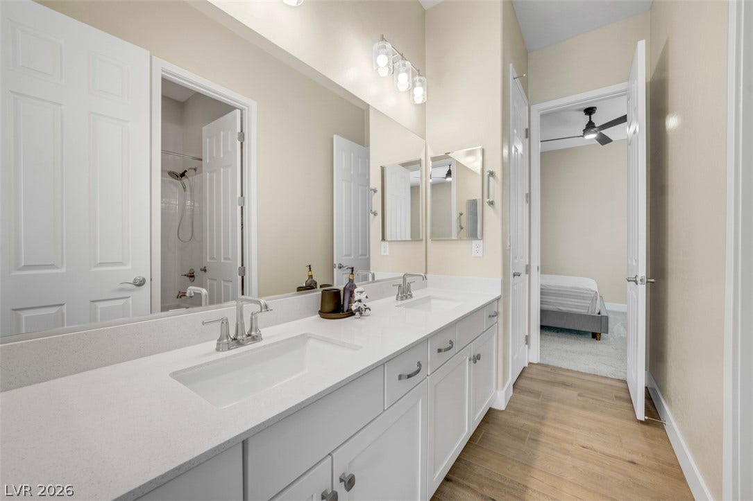 A spacious double vanity offers abundant storage and direct access to the adjoining bedroom.