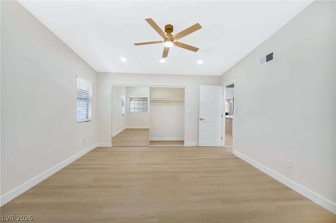 Smooth wood-style flooring runs through this comfortable space featuring a mirrored closet.