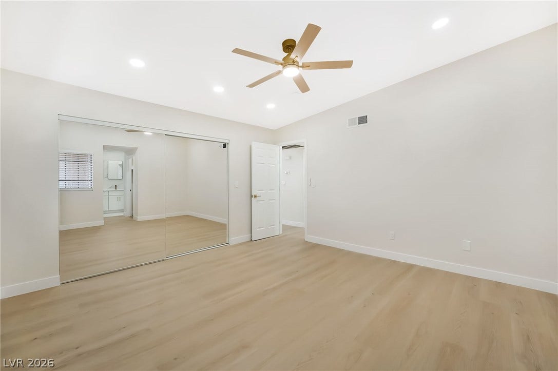 Smooth wood floors and recessed lighting enhance this versatile bedroom space.