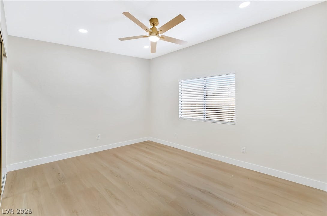 Smooth wood floors and recessed lighting define this versatile, clean-lined bedroom space.