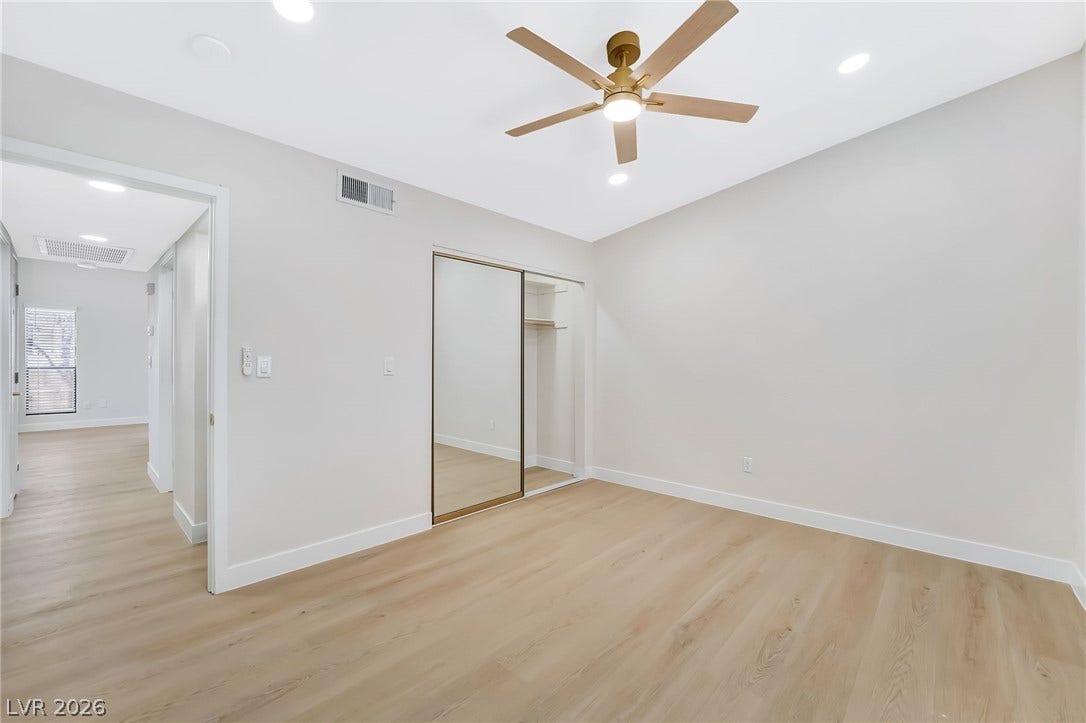 Gleaming wood floors and mirrored closet doors enrich this bright bedroom space.