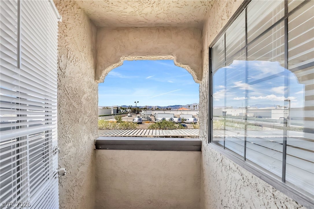 An arched opening frames mountain views from this private outdoor space.