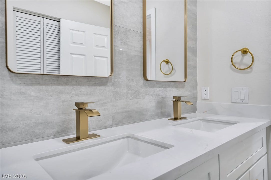 Elegant gold hardware pairs beautifully with the dual vanity in this modern washroom.