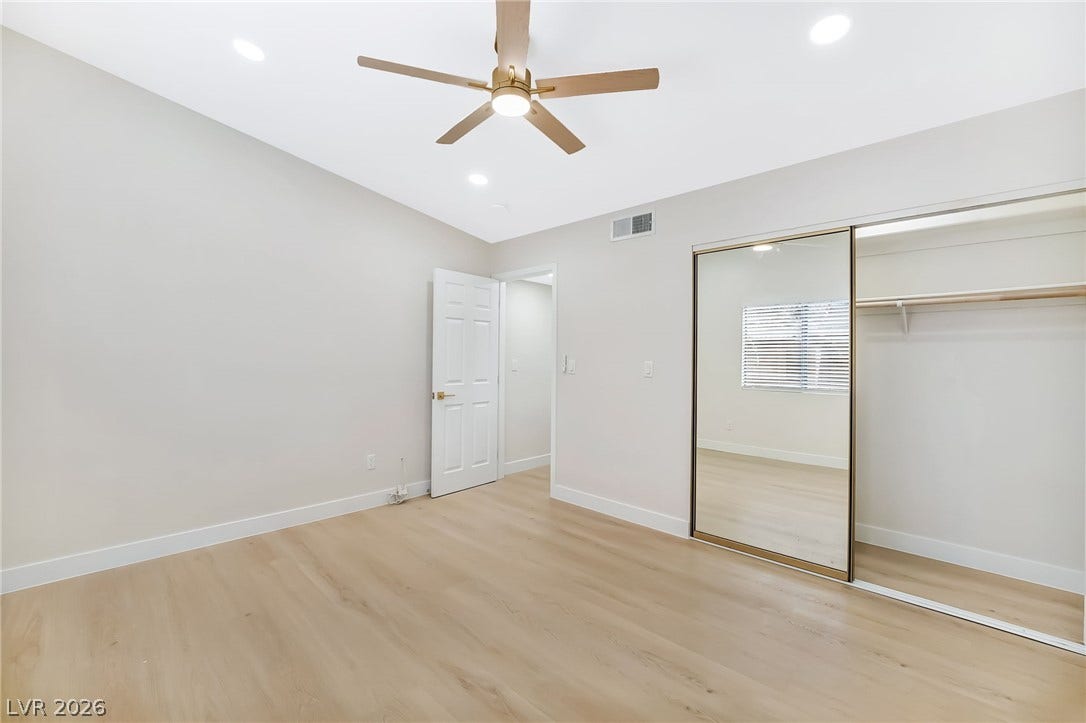 Smooth wood floors and recessed lighting anchor this versatile secondary bedroom space.