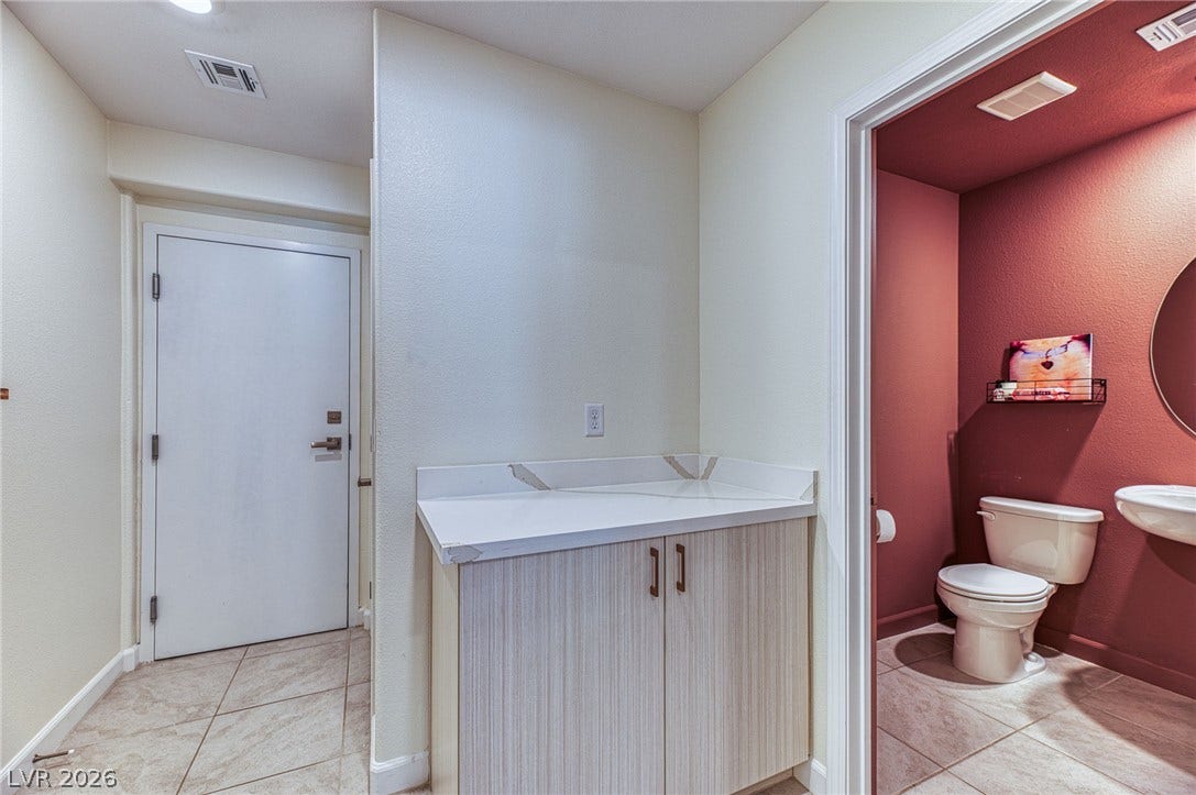 264 Banished Avenue, #2, North Las Vegas, NV 89031 Functional interior features include a vanity with counter space and an adjacent well-appointed lavatory.