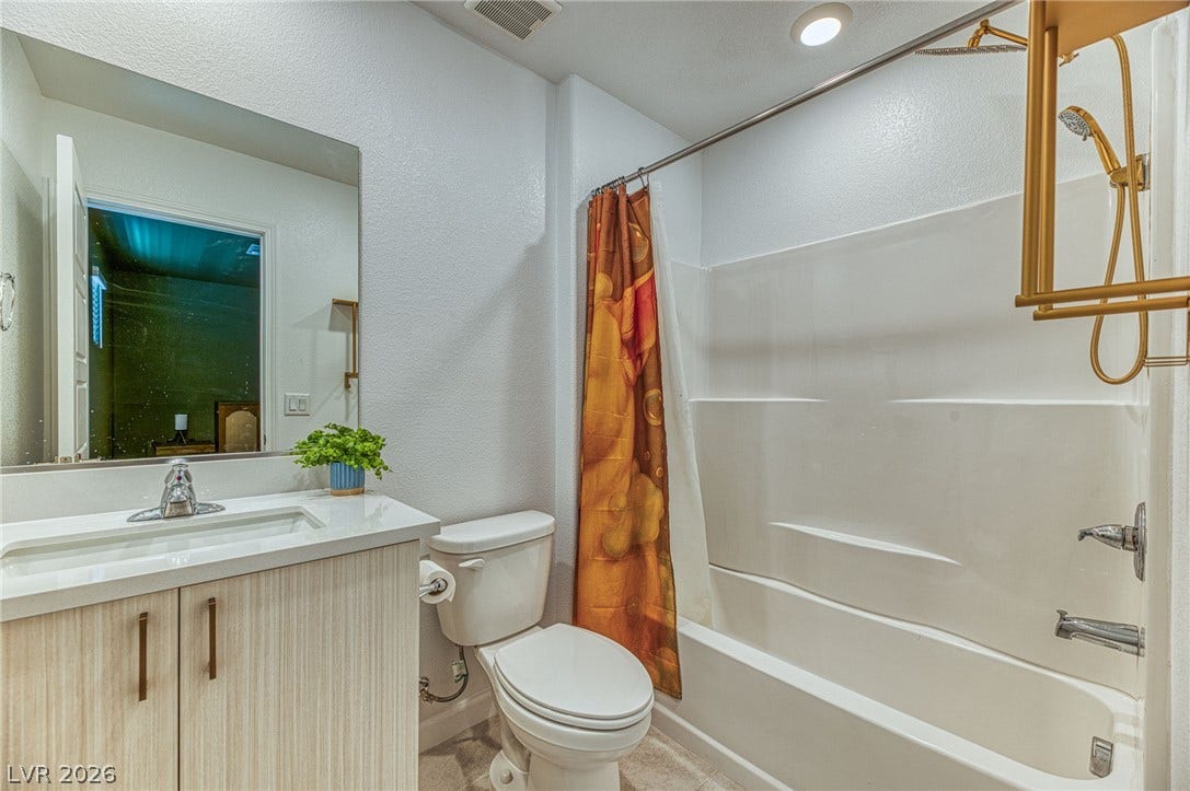 264 Banished Avenue, #2, North Las Vegas, NV 89031 A well-appointed bathroom features a sleek vanity, convenient commode, and an inviting shower-tub combination.