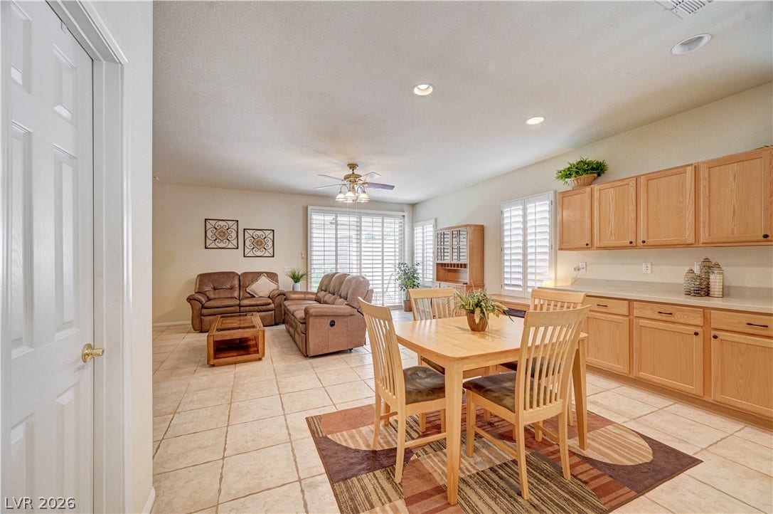 An open floor plan seamlessly connects the kitchen cabinetry, dining area, and living space.