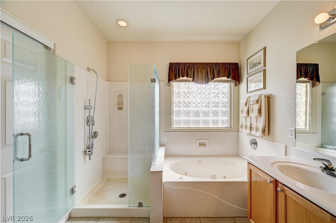 A spacious bathroom features a walk-in shower alongside a deep soaking tub.