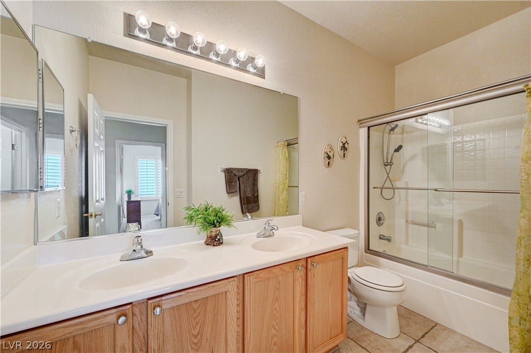 Double vanities and tile flooring elevate this well-appointed bathroom.