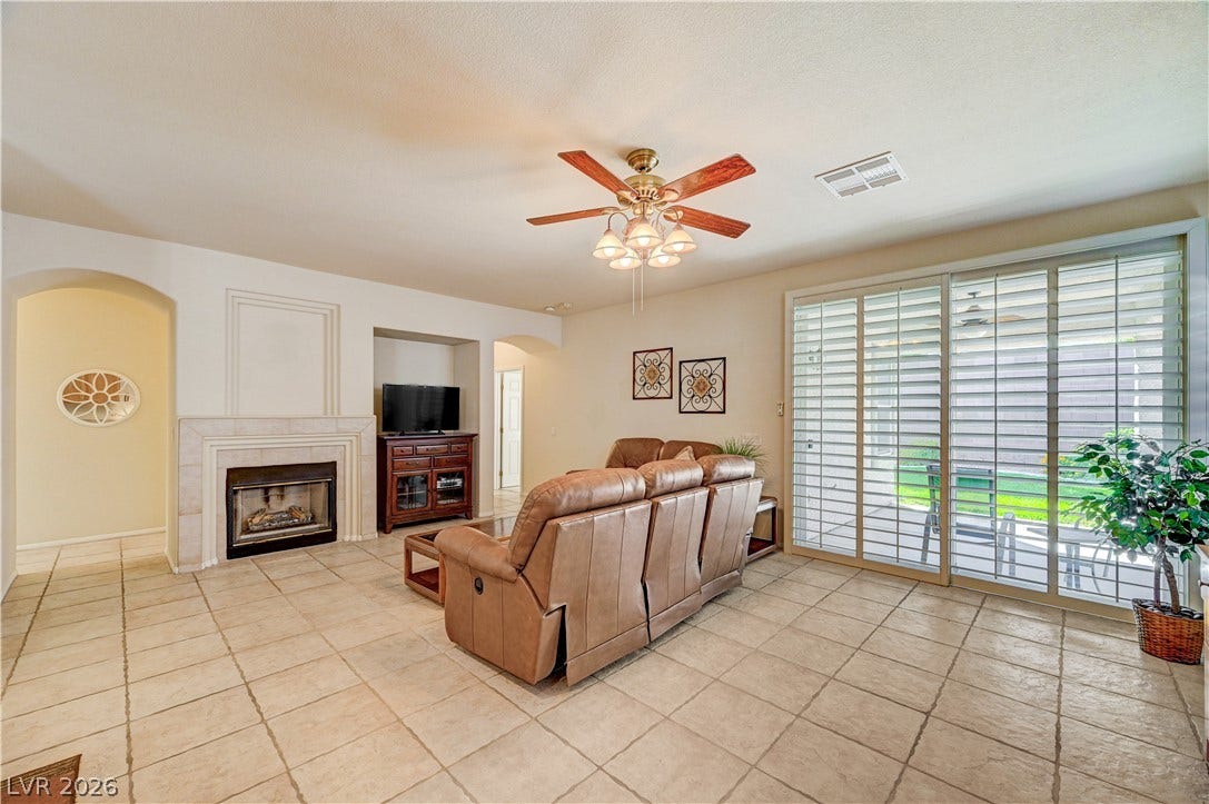 Tile flooring and a cozy fireplace define this comfortable living space with sliding glass doors.