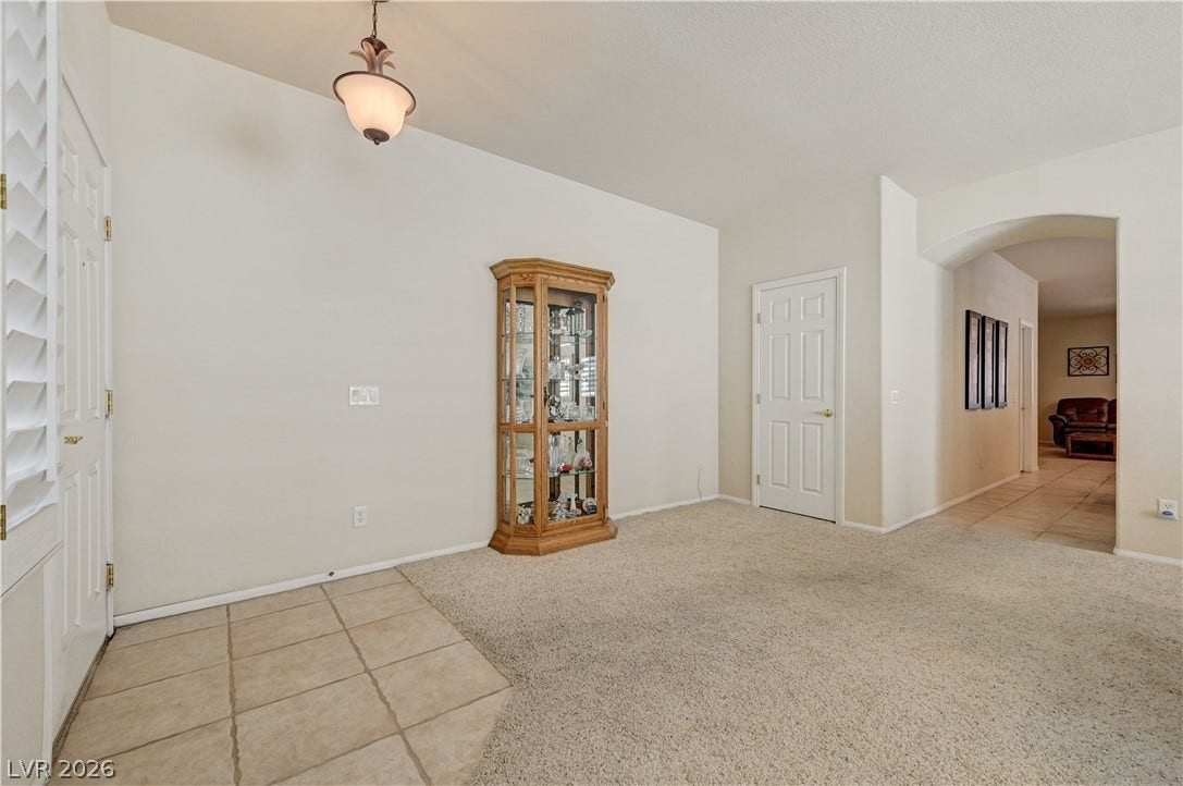 Tiled entryway leads directly into a carpeted living space with arched transitions.