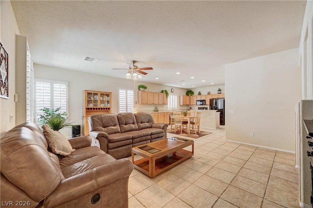 Tiled flooring and natural light from shuttered windows define this open-plan central living space.