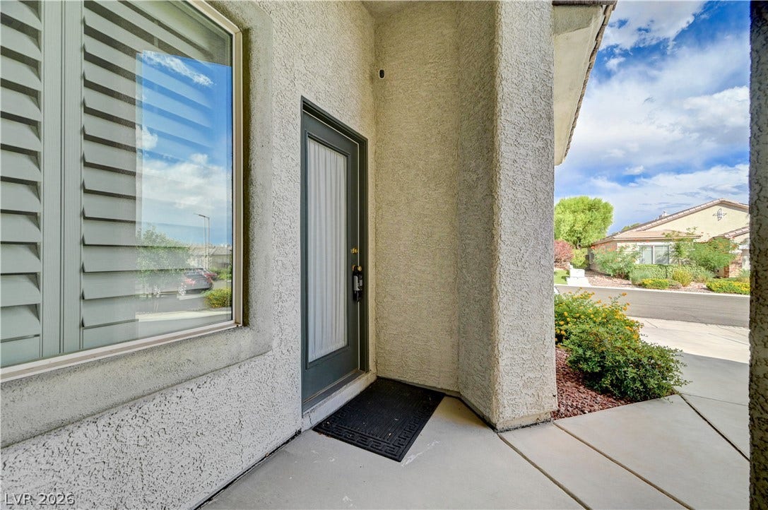 CASITA ENTRY   glass-paneled door surrounded by classic stucco walls.