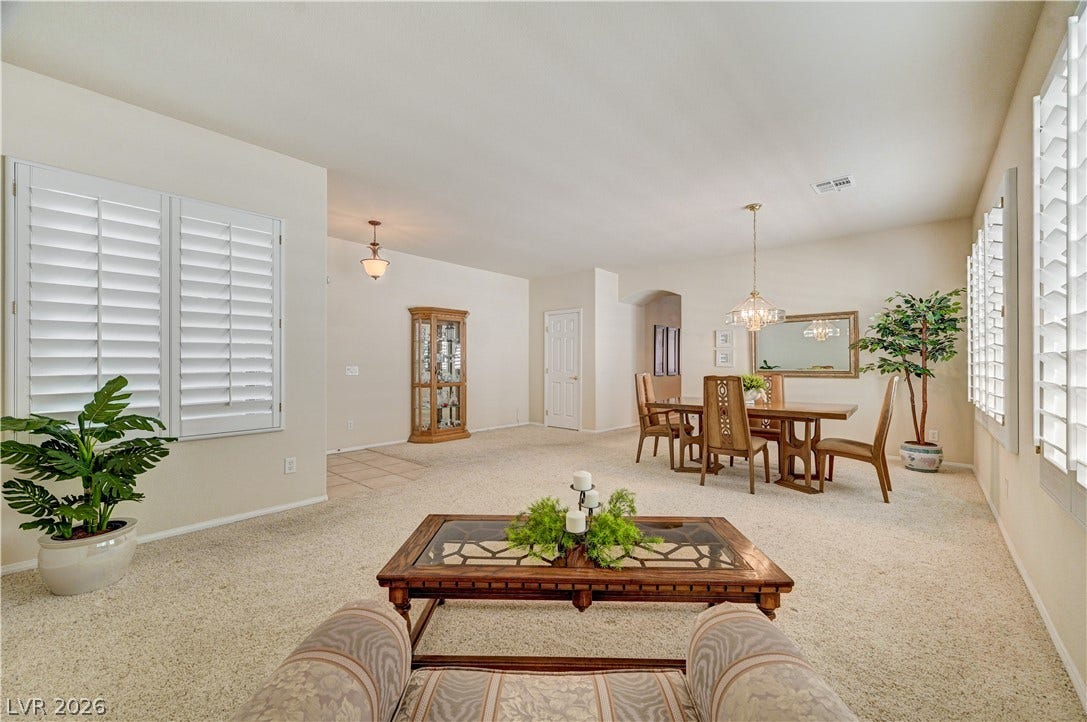 An open floor plan connects the living and dining areas under high ceilings.