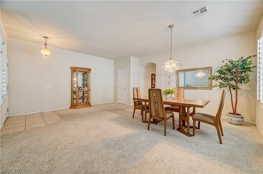 An open dining area showcases soft neutral carpeting alongside a tiled entry.