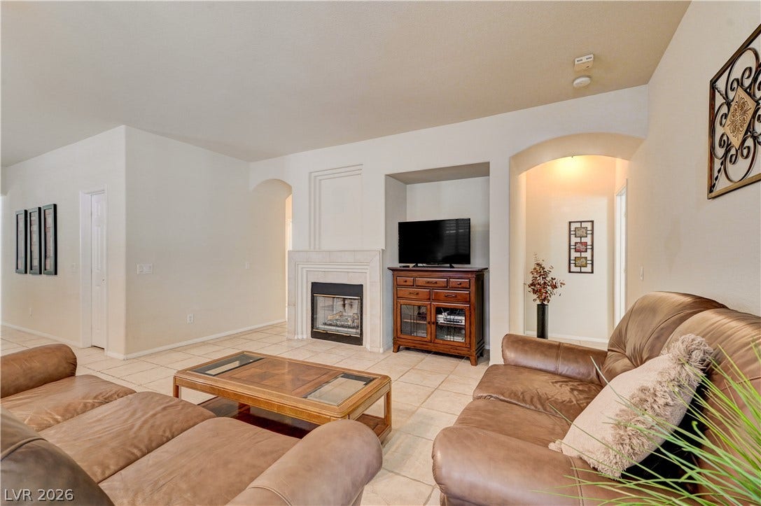 Tiled flooring and a classic fireplace anchor this comfortable, open-concept living area.