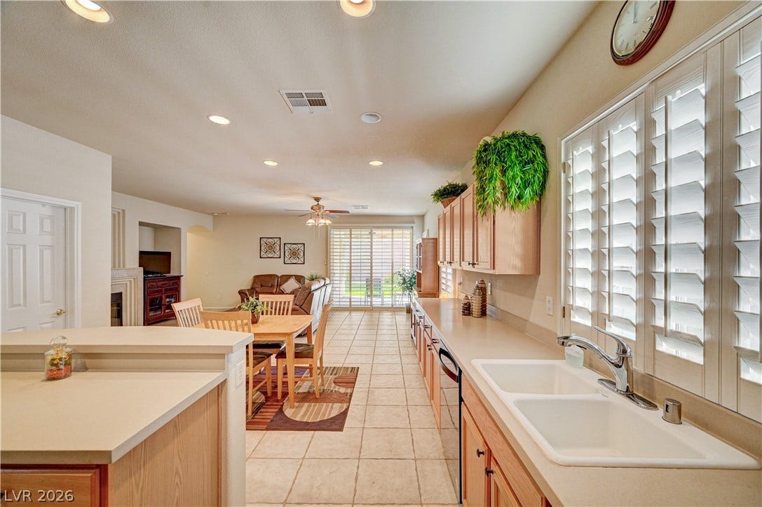 Tile flooring and an open layout connect the kitchen to the dining and living areas.