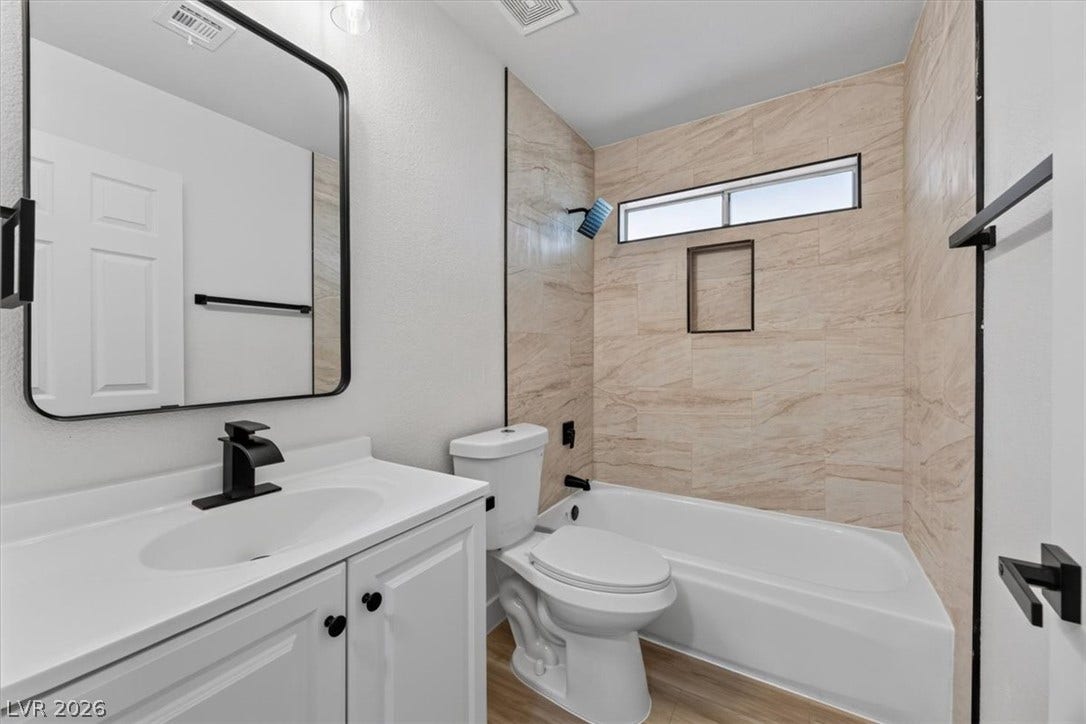4454 W Desert Inn Road, #D, Las Vegas, NV 89102 A modern bathroom features a tiled shower surround and a white vanity with black hardware.