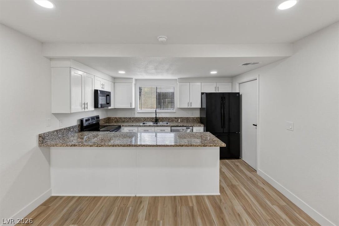 4454 W Desert Inn Road, #D, Las Vegas, NV 89102 Polished granite countertops and warm wood-toned flooring anchor this open culinary workspace.