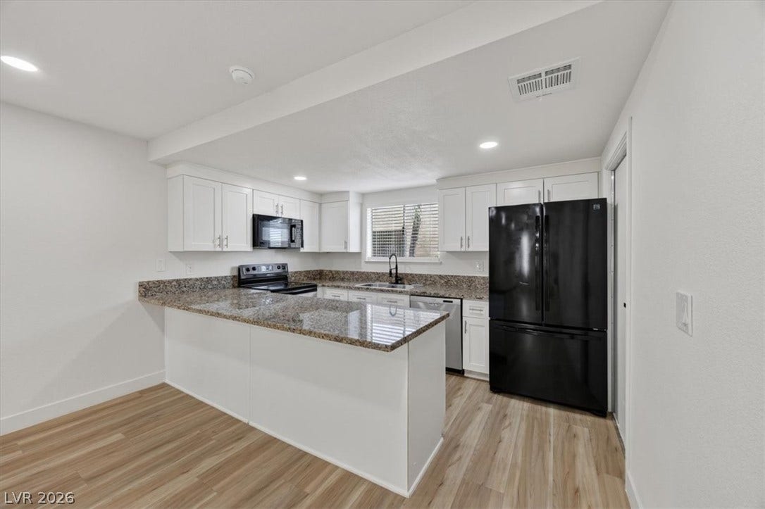 4454 W Desert Inn Road, #D, Las Vegas, NV 89102 Polished stone countertops and seamless wood flooring define this open kitchen design.