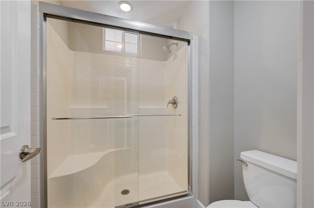 1525 Spiced Wine Avenue, #3105, Henderson, NV 89074 Modern sliding glass doors enclose a tiled shower unit featuring a built-in bench seat.