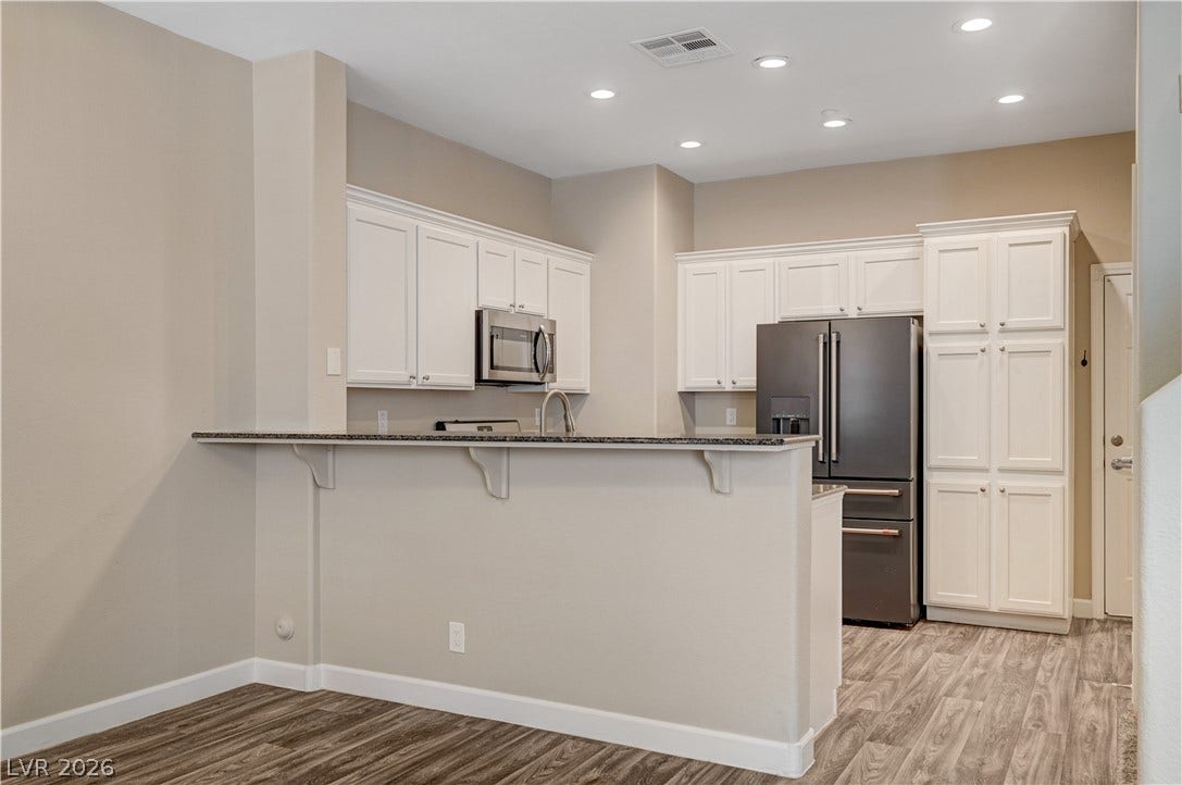 1525 Spiced Wine Avenue, #3105, Henderson, NV 89074 Recessed lighting illuminates this modern kitchen featuring white cabinetry and stainless steel appliances.