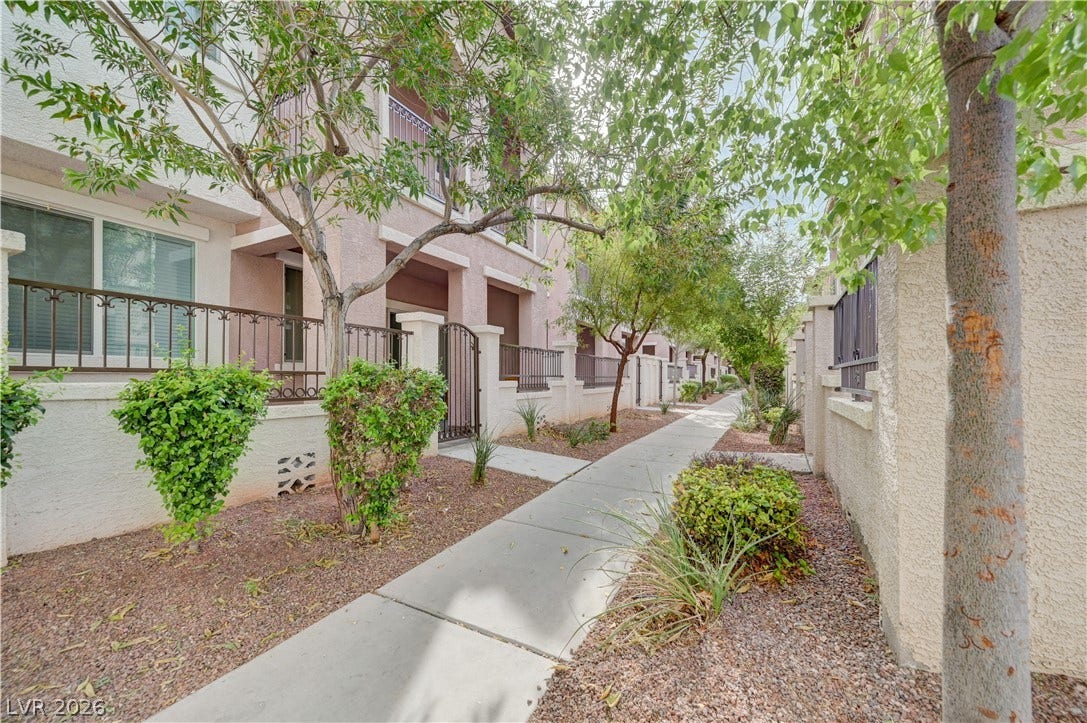 1525 Spiced Wine Avenue, #3105, Henderson, NV 89074 Mature trees shade a tidy concrete pathway leading past private entrances and gated courtyards.