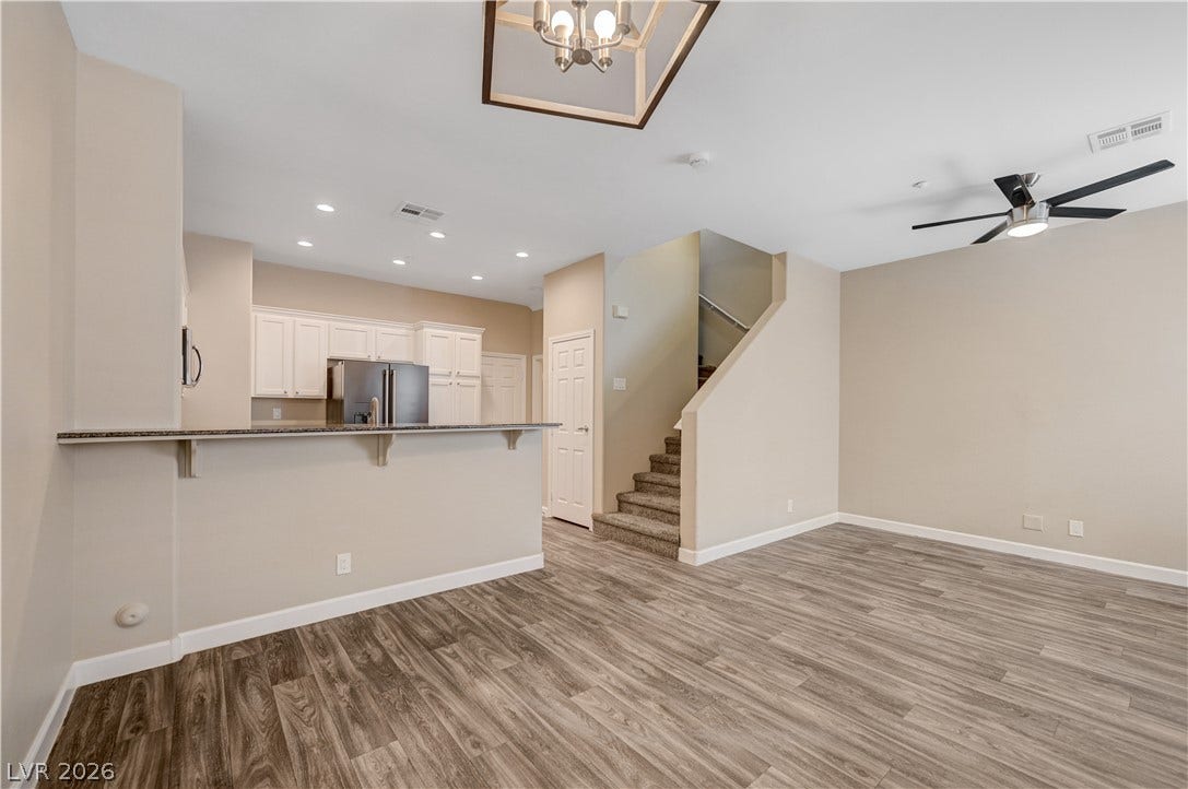 1525 Spiced Wine Avenue, #3105, Henderson, NV 89074 Rich wood-inspired floors anchor this open-concept main level seamlessly connecting the living area and kitchen.
