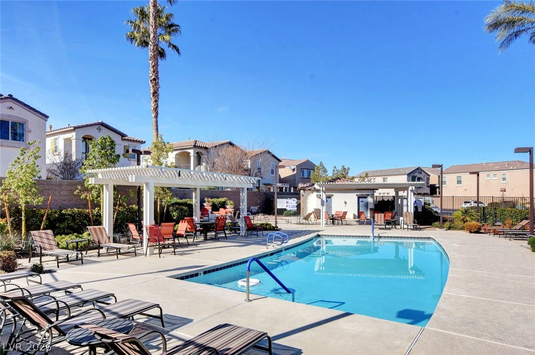 1525 Spiced Wine Avenue, #3105, Henderson, NV 89074 A sparkling community pool sits framed by classic pergolas under clear blue skies.
