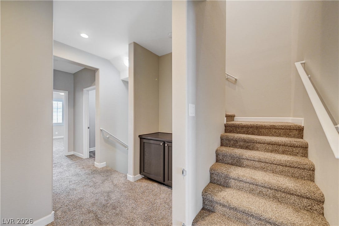 1525 Spiced Wine Avenue, #3105, Henderson, NV 89074 Carpeted stairs ascend from a hallway featuring neutral walls and built-in cabinetry on second floor.