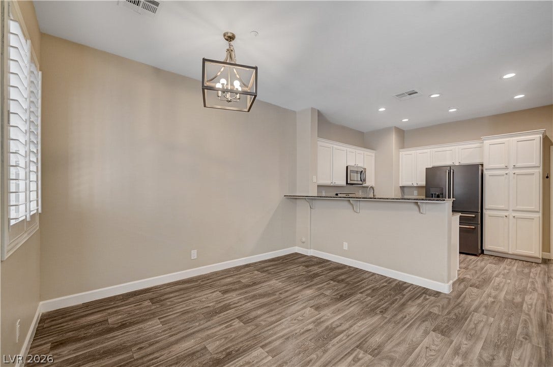 1525 Spiced Wine Avenue, #3105, Henderson, NV 89074 Rich wood-look flooring anchors this open dining space and adjoining kitchen.