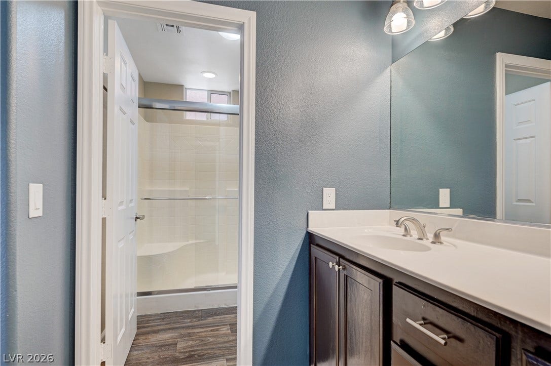 1525 Spiced Wine Avenue, #3105, Henderson, NV 89074 A classic vanity sits adjacent to a modern walk-in shower with a built-in bench.