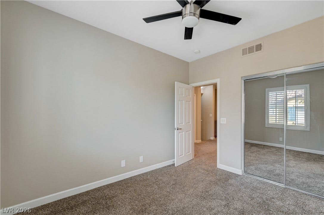 1525 Spiced Wine Avenue, #3105, Henderson, NV 89074 Plush carpeting anchors this versatile room featuring sliding mirrored closet doors and high ceilings.