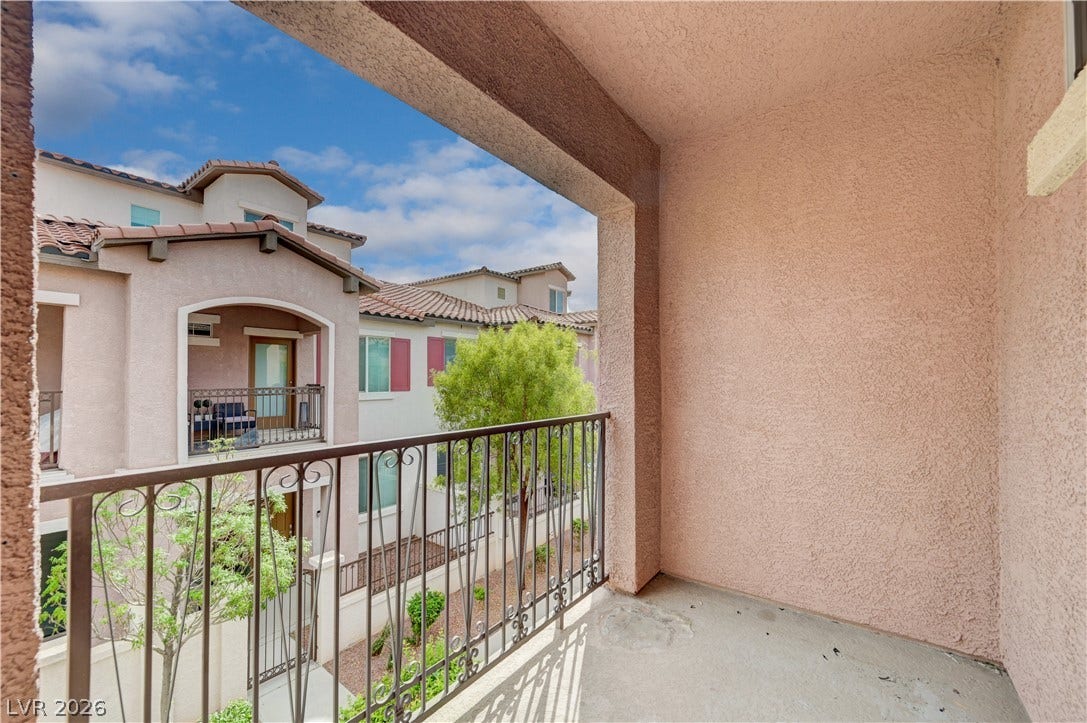 1525 Spiced Wine Avenue, #3105, Henderson, NV 89074 Off primary bedroom - concrete flooring and textured stucco walls frame a private covered balcony overlooking neighborhood views.