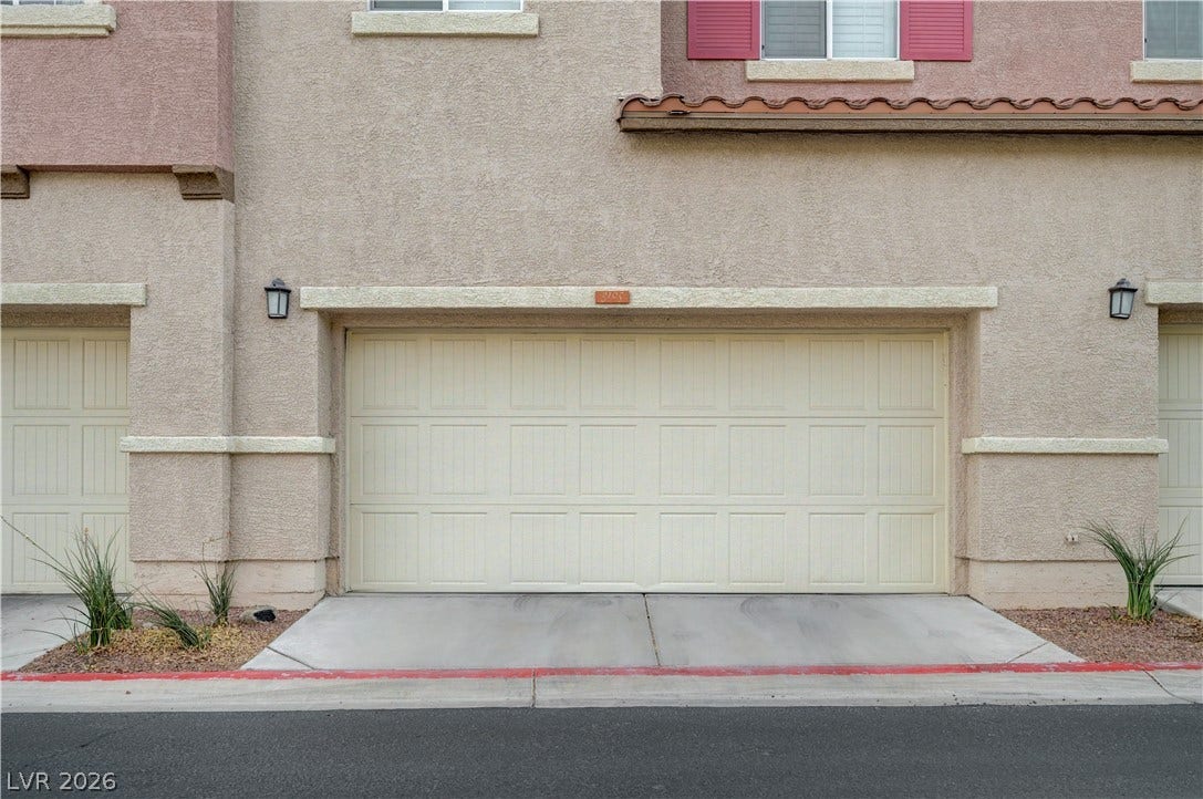 1525 Spiced Wine Avenue, #3105, Henderson, NV 89074 An attached multi-car garage features a clean concrete driveway and a textured stucco exterior.