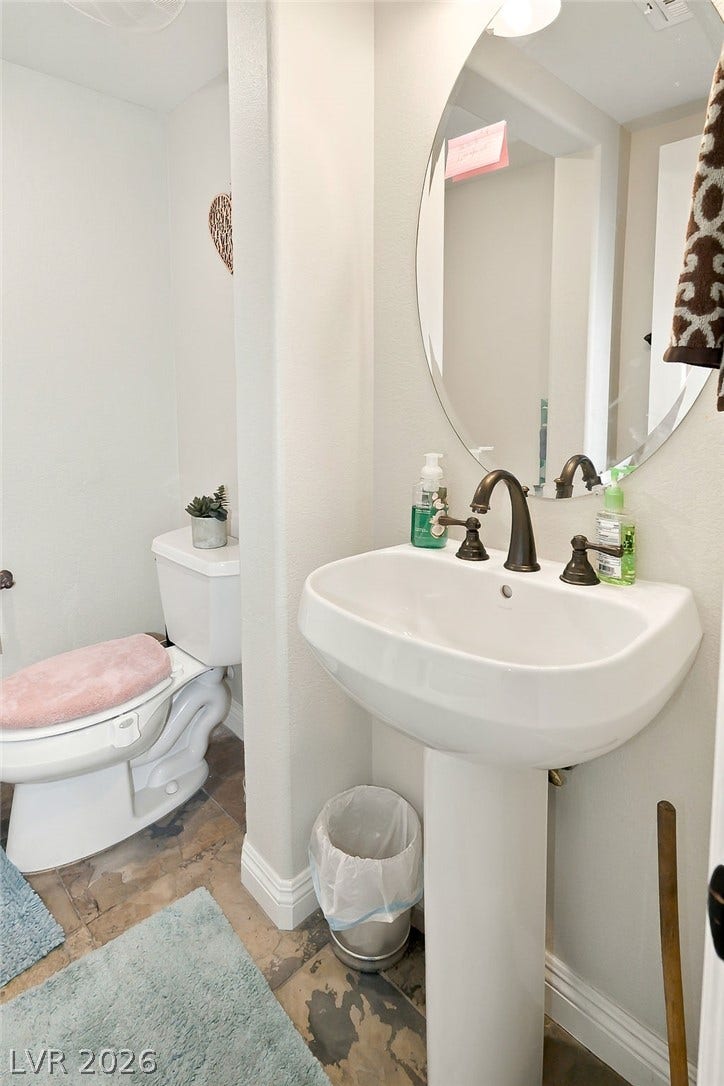 A classic pedestal sink pairs with patterned tile floors in this compact powder room.