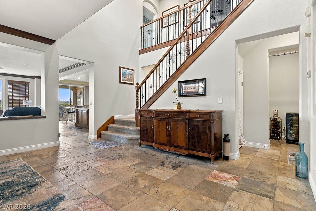 Dramatic high ceilings and natural stone tile flooring define this soaring entry hall.