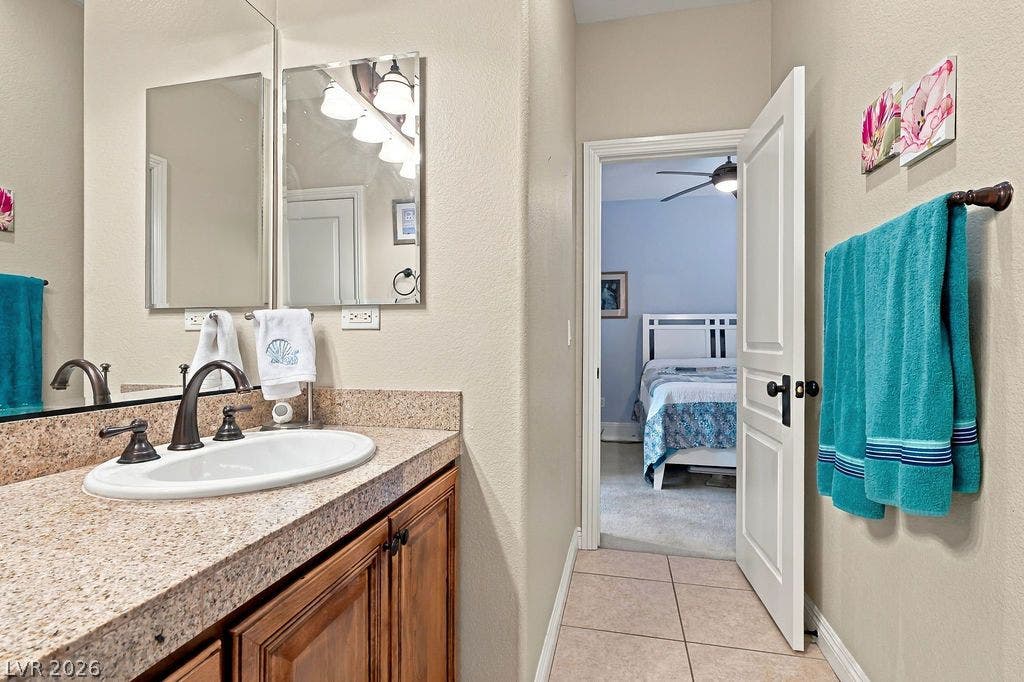 An open doorway connects the tiled bathroom to a carpeted bedroom suite.