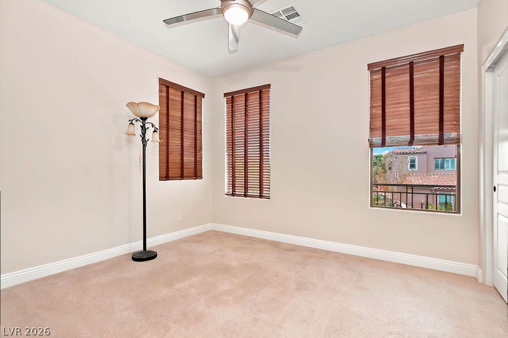 Warm carpeting and multiple windows define this versatile bedroom space.
