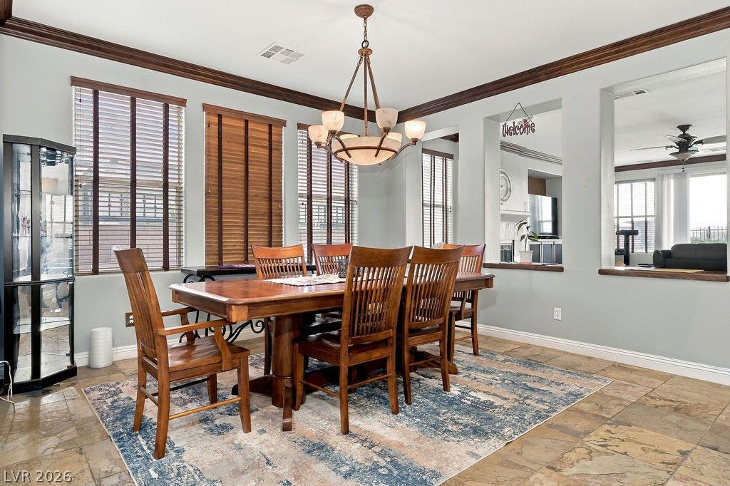 Crown molding and tiled floors frame a formal dining area with pass-through wall openings.