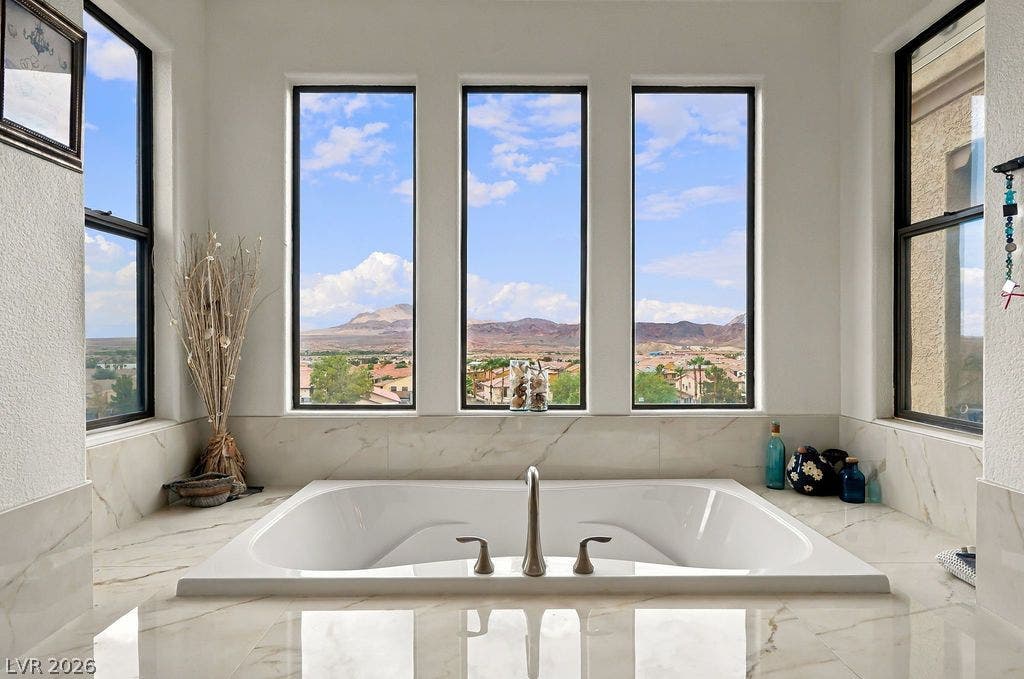 Large picture windows frame expansive desert and mountain views from this deep soaking tub.