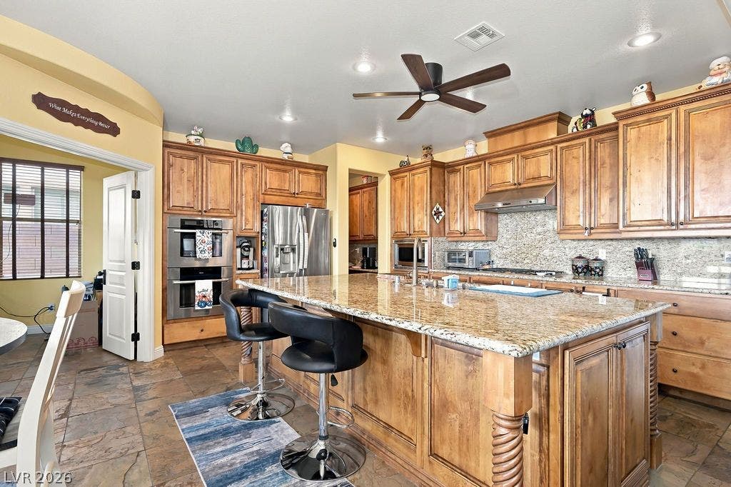 Rich wood cabinetry paired with premium granite countertops defines this spacious open-concept kitchen.