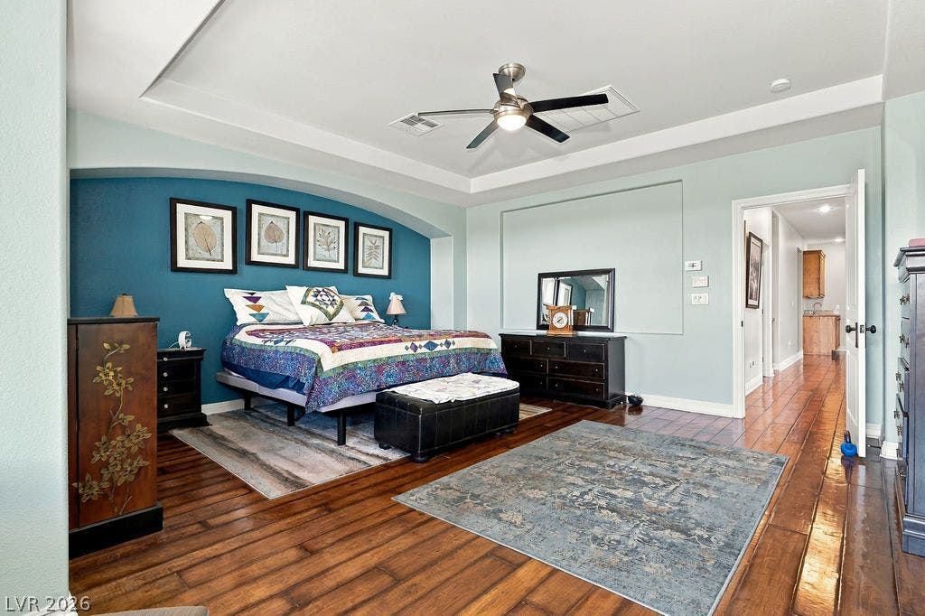 Gleaming hardwood floors and a deeply recessed tray ceiling define this elegant private bedroom.