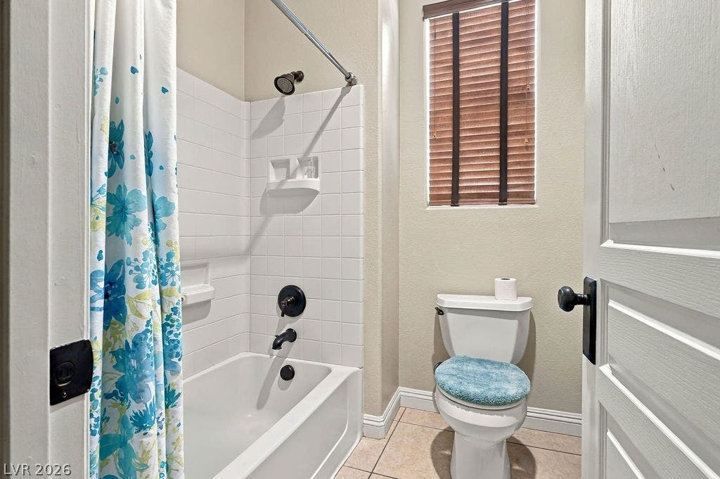 A classic tiled shower and tub combination coordinates with neutral floor tiling.