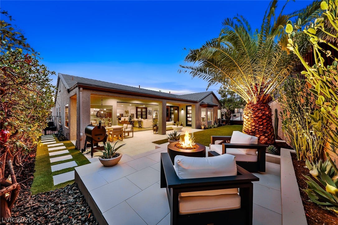 2601 Arimo Drive, Henderson, NV 89052 An inviting backyard patio features stone tile flooring, a built-in fire pit, and professional landscaping.