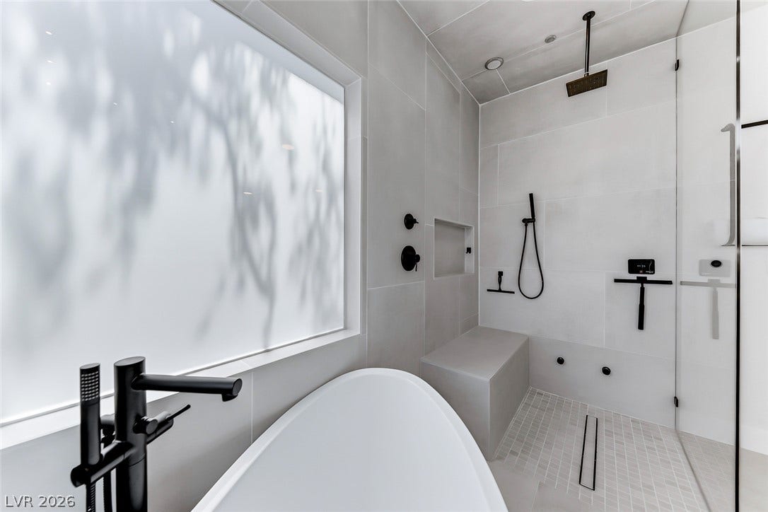 2601 Arimo Drive, Henderson, NV 89052 A glass-enclosed shower and freestanding tub create a spa-like retreat with modern fixtures.